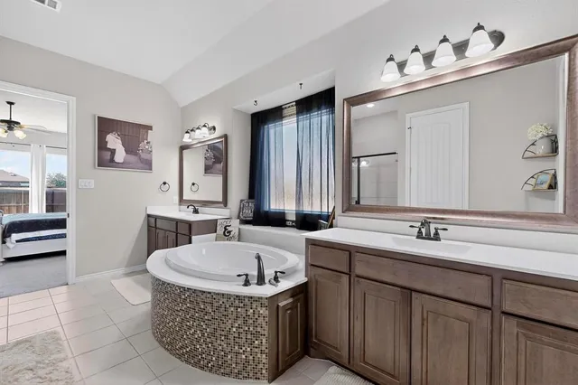 a bathroom with a tub sink and mirror