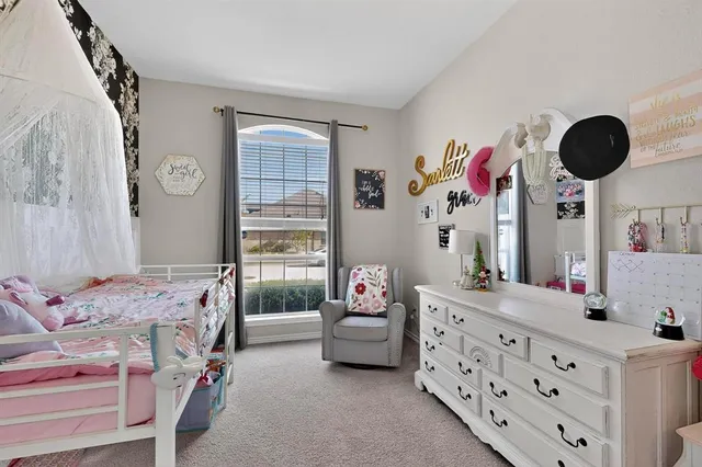 a bedroom with a bed dresser and window