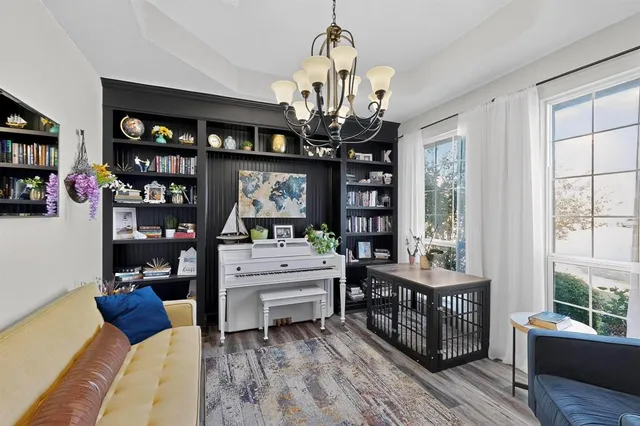 a living room with furniture a chandelier and a bookshelf