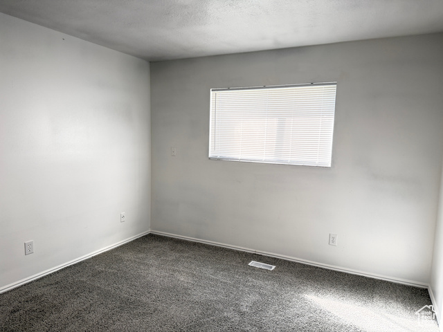 420 North 200 West Logan, UT 84321 - Photo 12 of 13 Carpeted spare room featuring a textured ceiling and baseboards