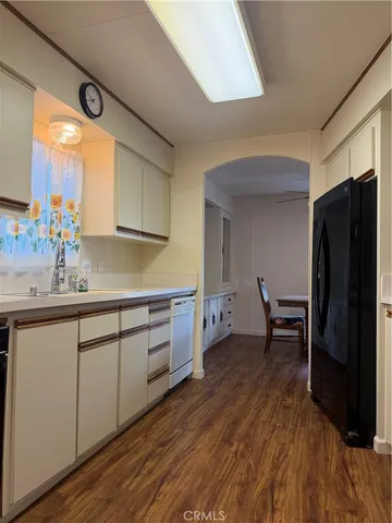 a kitchen with a sink a refrigerator and wooden cabinets