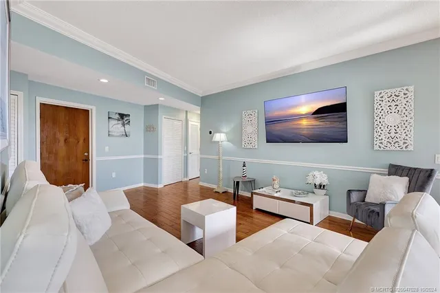 a dining room with wooden floor a chandelier a wooden table and chairs