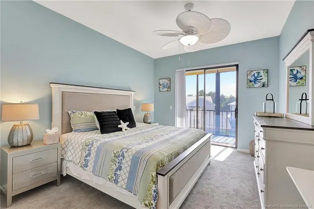 a spacious bedroom with a large bed and a chandelier fan