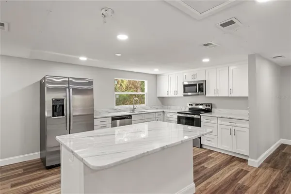 a kitchen with stainless steel appliances granite countertop a sink stove and refrigerator