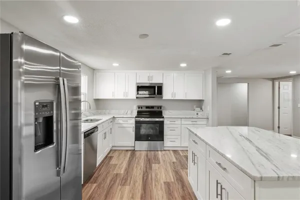 a kitchen with white cabinets and stainless steel appliances