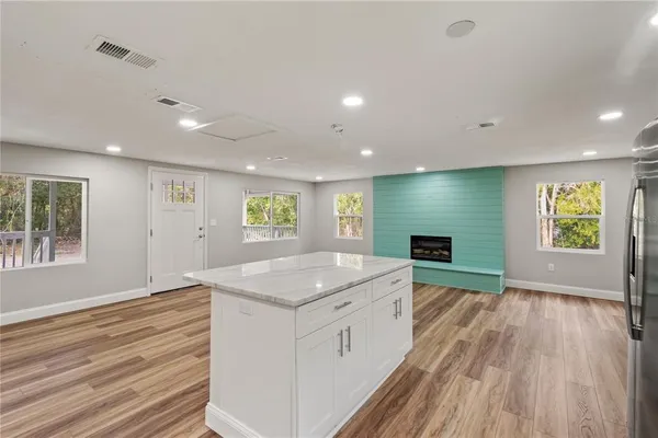 a kitchen with a sink window and a fireplace