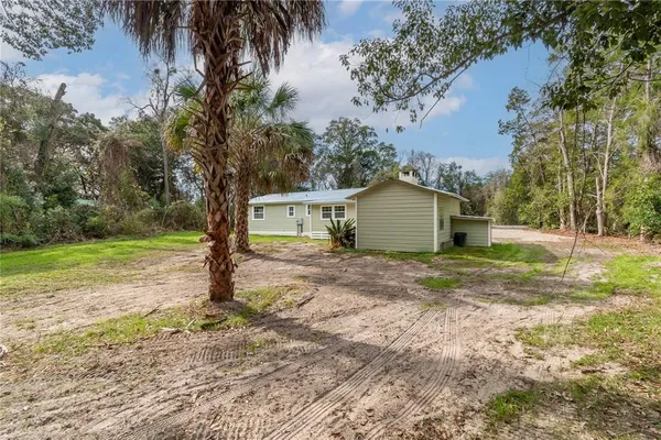 a view of a house with backyard and trees