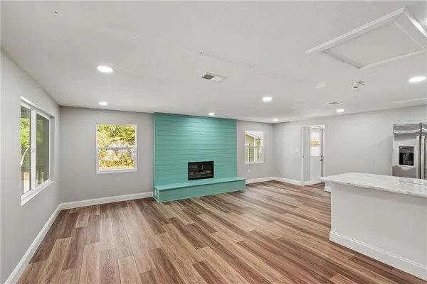 a view of an empty room with a window and fire place