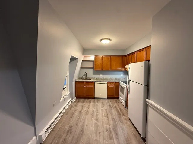 a kitchen with refrigerator a microwave and wooden floor