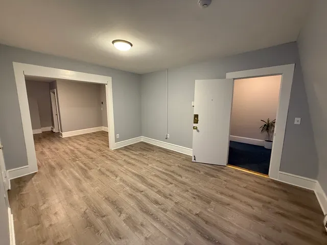 a view of an empty room with wooden floor