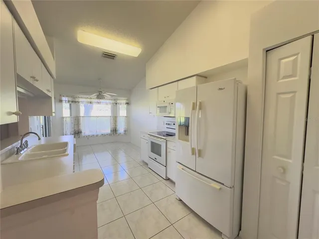 a kitchen with white cabinets and white appliances