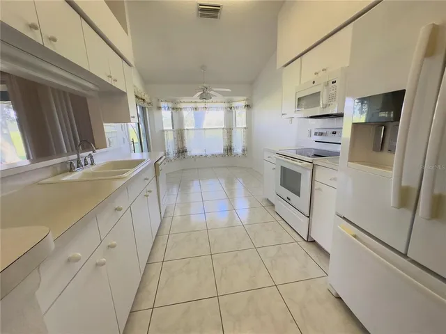 a large kitchen with a stove a refrigerator a sink and dishwasher