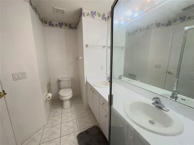 a spacious bathroom with a double vanity sink mirror and shower