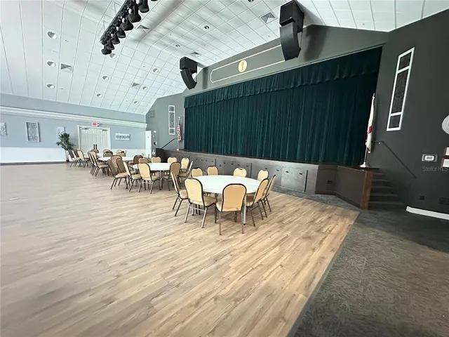 a room with pool table two windows and a rug