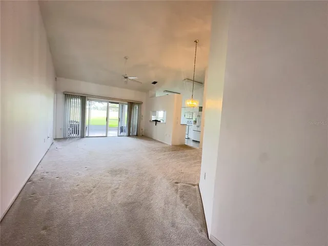 a view of a big room with windows and chandelier fan