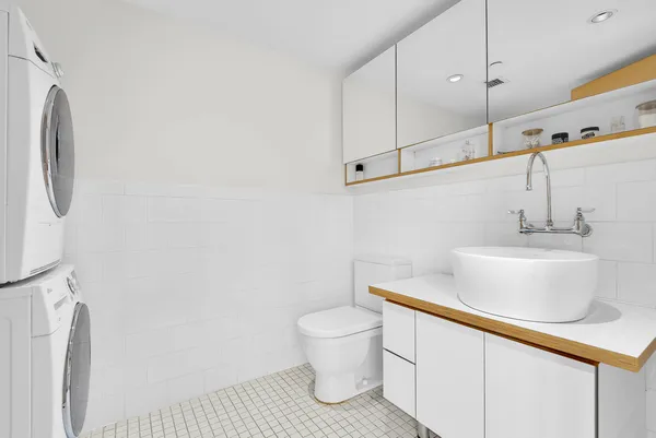 a kitchen with stainless steel appliances a refrigerator a stove a sink dishwasher and white cabinets with wooden floor