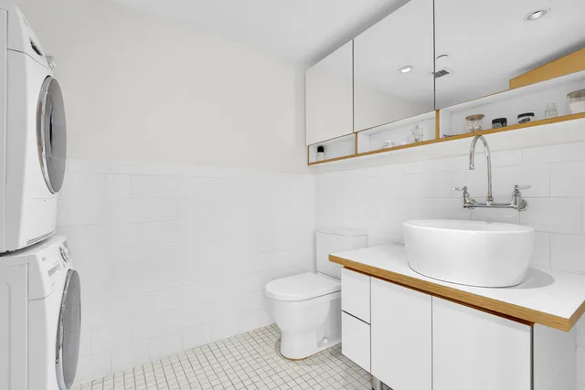 a kitchen with stainless steel appliances a refrigerator a stove a sink dishwasher and white cabinets with wooden floor