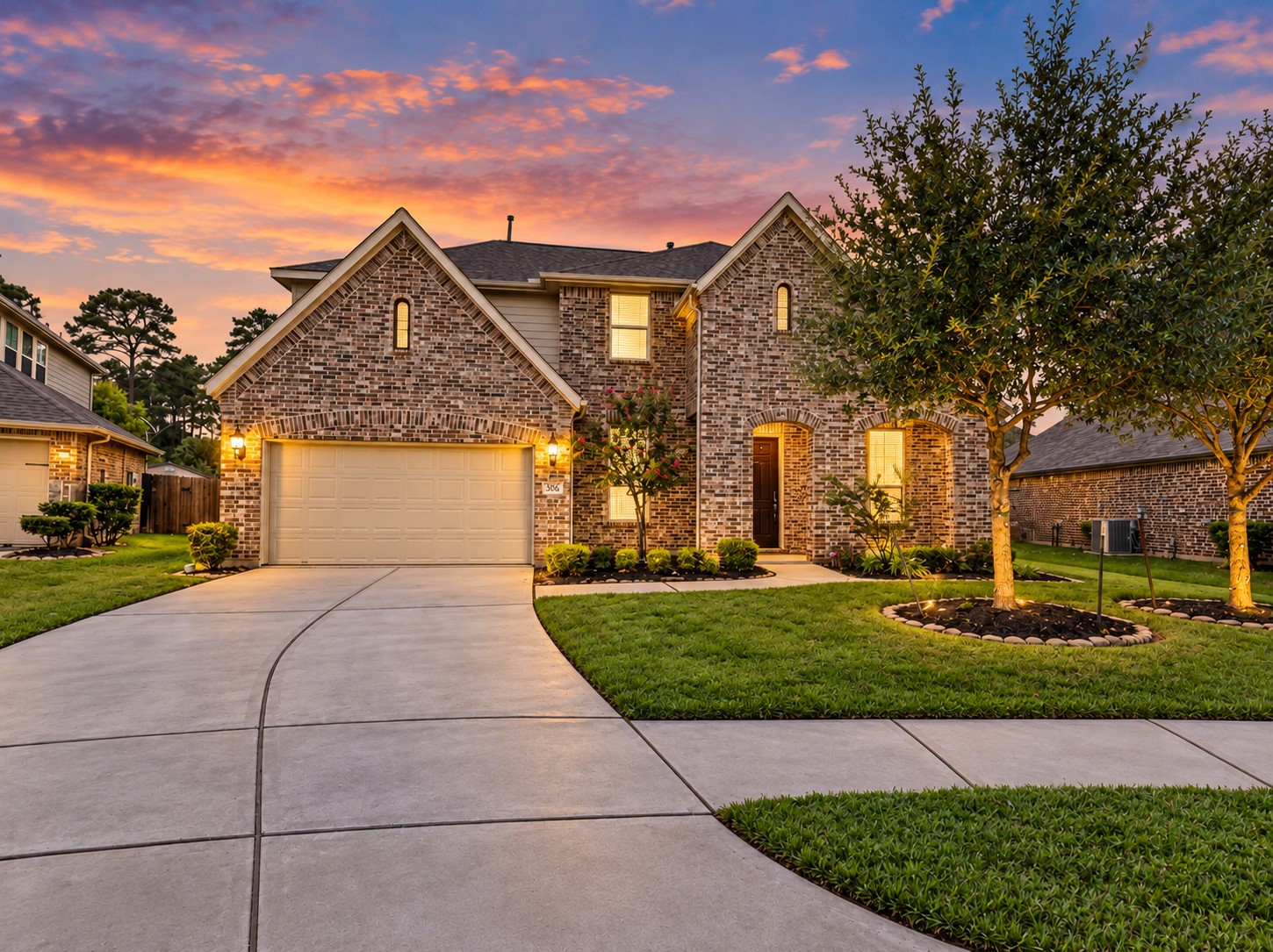 9626 Invergarry Way Tomball, TX 77375 - Photo 1 of 43 Twilight view of 9626 Invergarry Way showcasing the two-story brick exterior, two-car garage, manicured lawn, mature landscaping, and inviting exterior lighting.