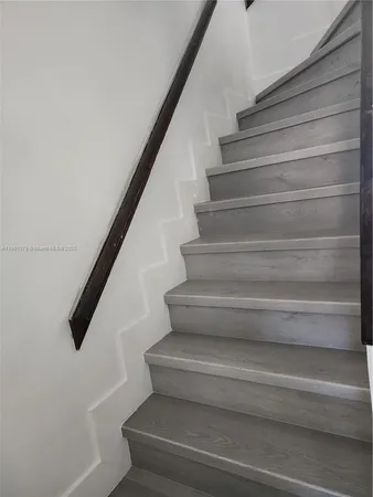 a view of staircase with white walls and a window
