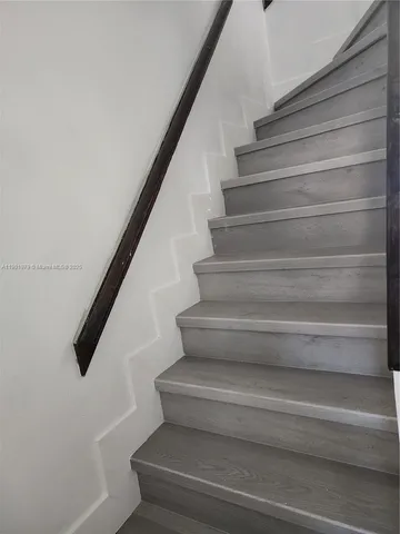 a view of staircase with white walls and a window