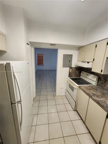 a kitchen with a sink a refrigerator and cabinets