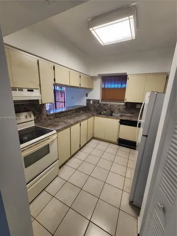 a kitchen with stainless steel appliances a stove a sink and a refrigerator