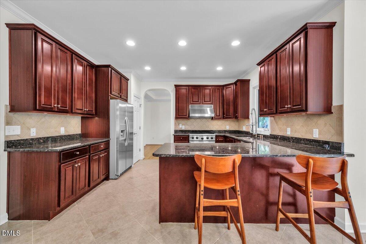 2908 Oak Bridge Drive Raleigh, NC 27610 - Photo 16 of 47 a kitchen with granite countertop wooden cabinets and stainless steel appliances