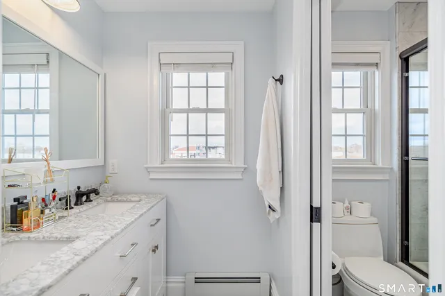 a bathroom with a granite countertop sink toilet and shower