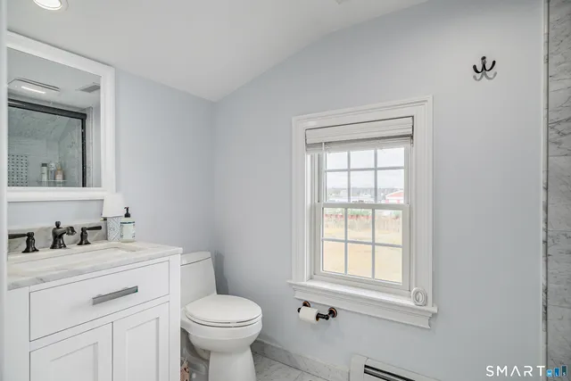 a bathroom with a toilet sink and mirror