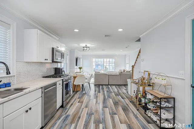 a large kitchen with stainless steel appliances a lot of counter space and a wooden floors