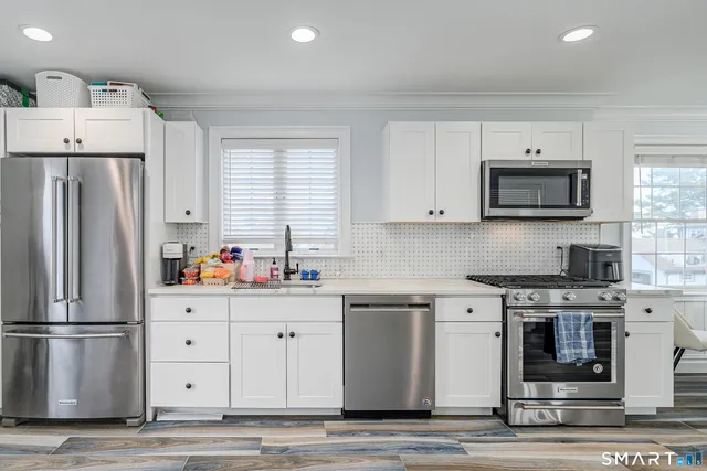 a kitchen with stainless steel appliances a refrigerator sink and microwave