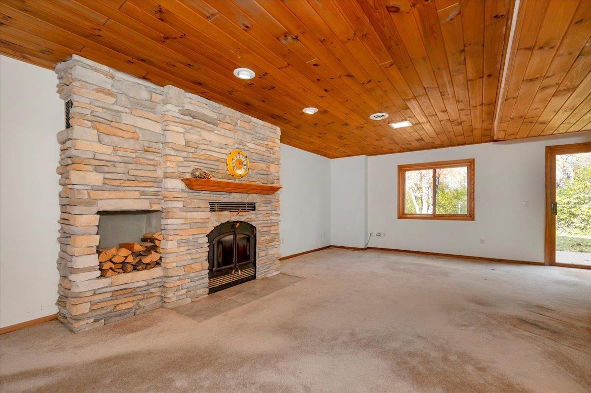 6373 Maple Grove Road Cloquet, MN 55720 - Photo 22 of 42 Unfurnished living room with carpet flooring and a stone fireplace