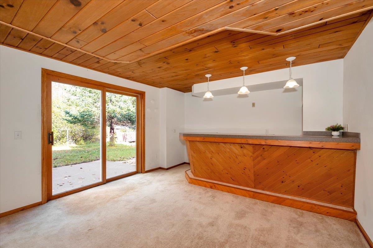 6373 Maple Grove Road Cloquet, MN 55720 - Photo 24 of 42 Indoor dry bar with wooden ceiling, pendant lighting, and light carpet