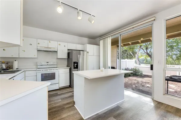 a kitchen with kitchen island a sink stove and refrigerator