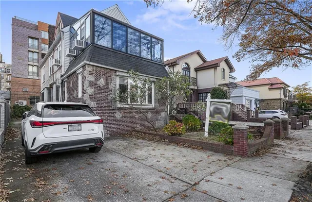 a car parked in front of a brick house