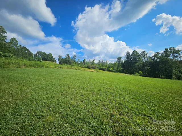 a view of a big yard with a house in the background