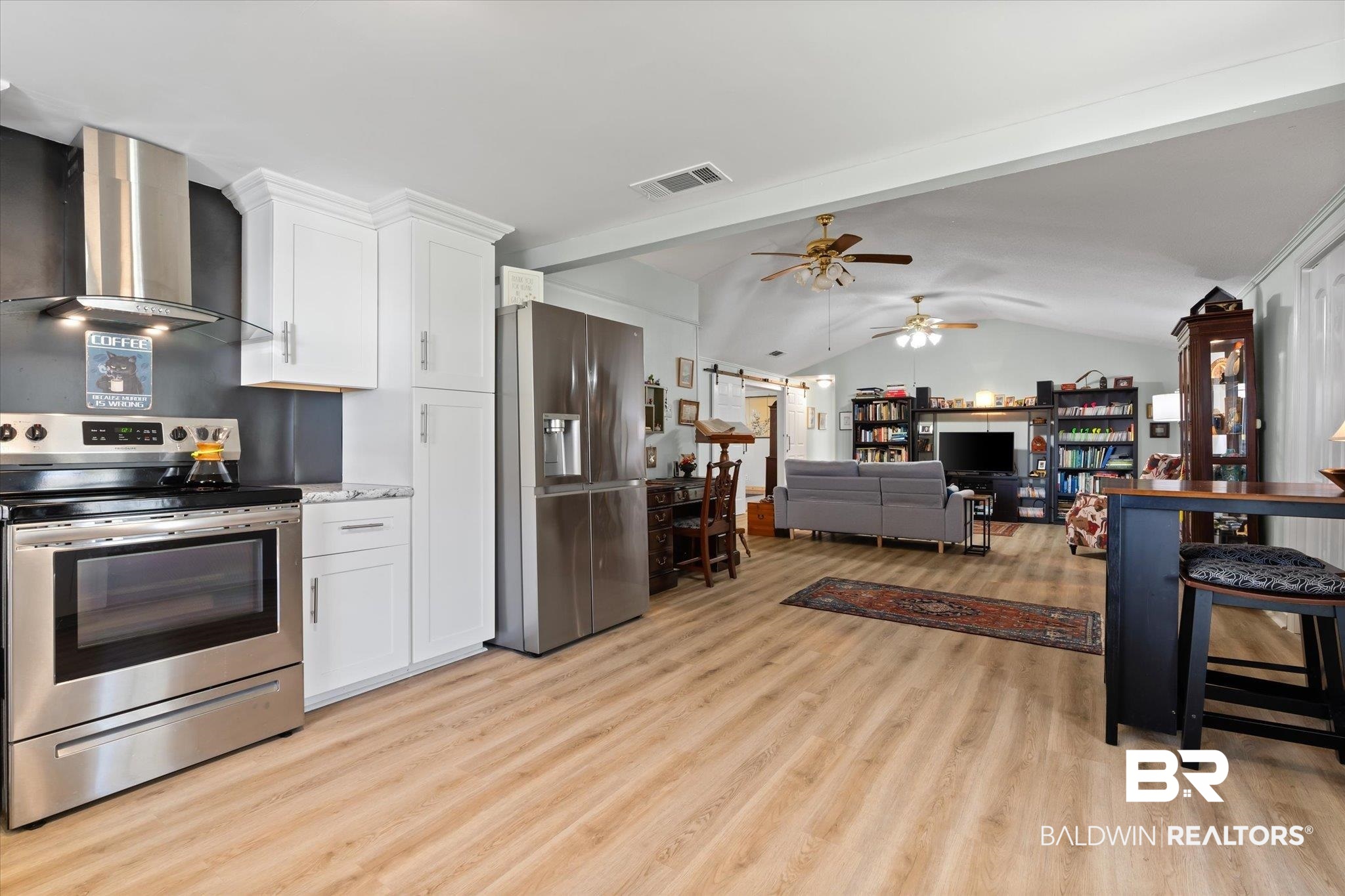 14280 Cat Deakle Road Grand Bay, AL 36541 - Photo 13 of 51 Kitchen featuring visible vents, lofted ceiling with beams, appliances with stainless steel finishes, light wood-style floors, and wall chimney range hood