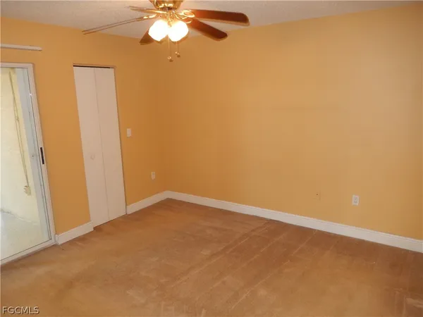 an empty room with a chandelier fan and a chandelier fan