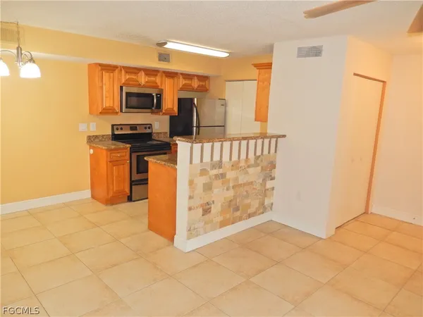 a view of kitchen with stainless steel appliances cabinets and refrigerator