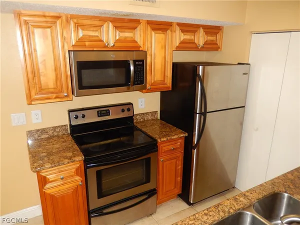 a kitchen with stainless steel appliances granite countertop a refrigerator and a stove top oven