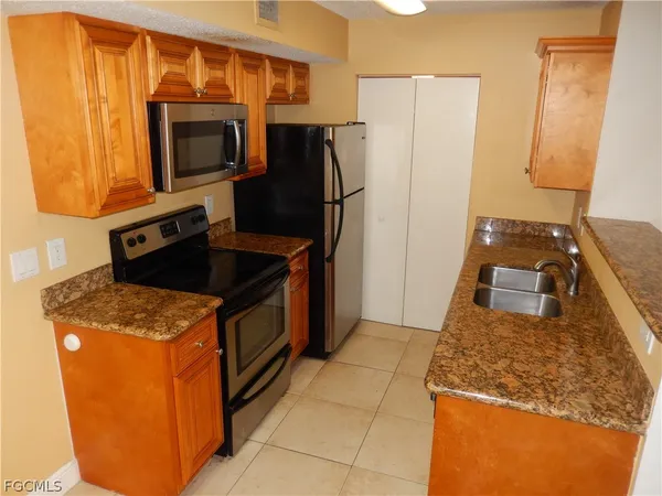 a kitchen with stainless steel appliances granite countertop a refrigerator stove and microwave