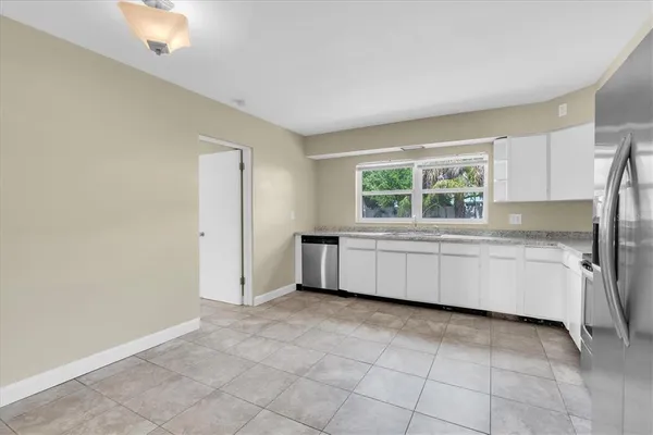 a kitchen with granite countertop white cabinets and stainless steel appliances