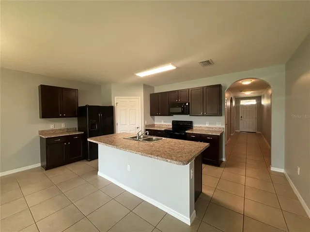 a kitchen with a sink a stove top oven and cabinets