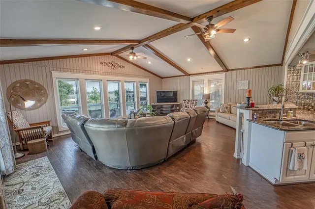 a living room with couches a dining table and chairs with wooden floor