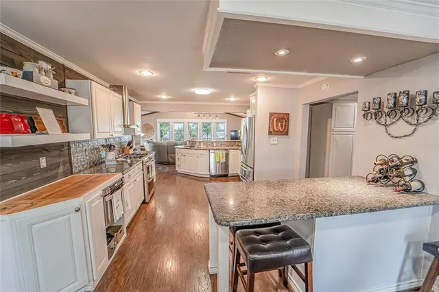 a kitchen with stainless steel appliances granite countertop a stove and a wooden cabinets
