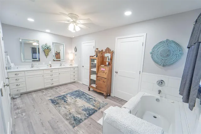 a view of a bedroom with wooden floor and ceiling fan
