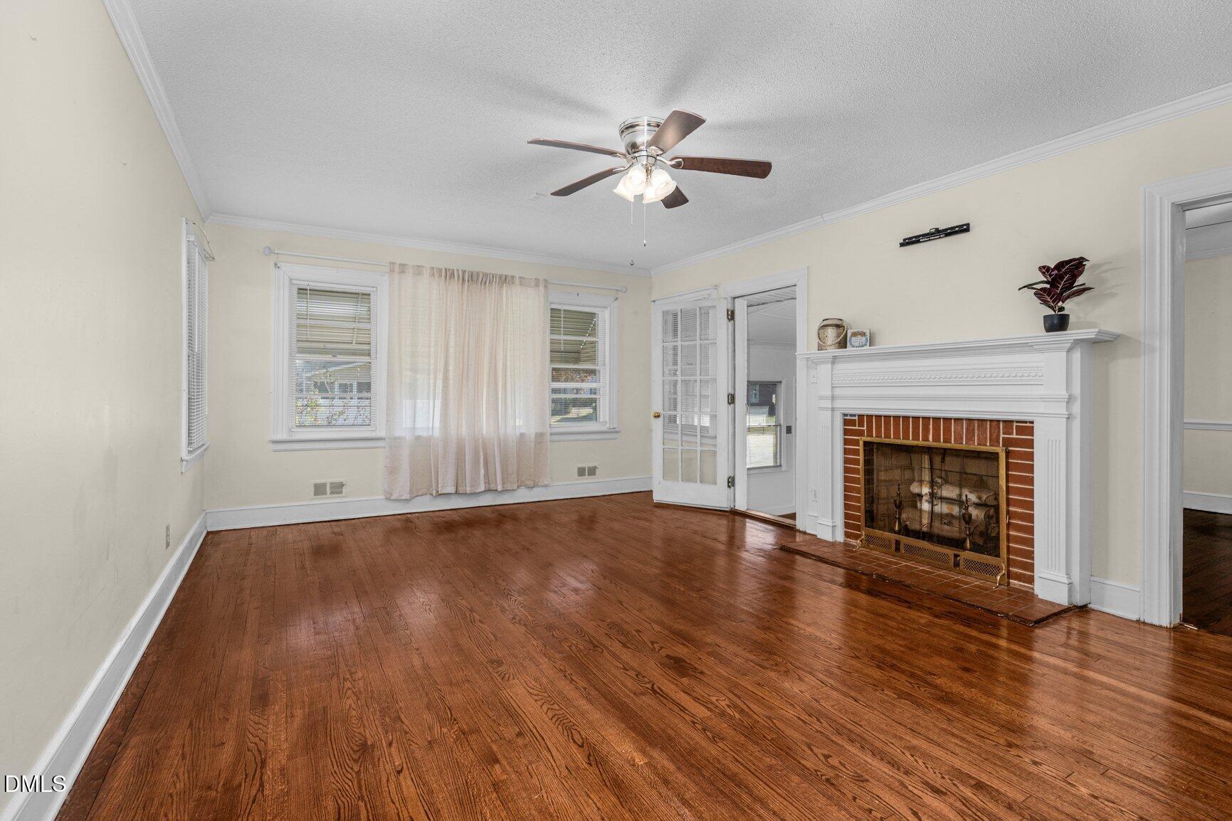 902 Treemont Road Northwest Wilson, NC 27896 - Photo 6 of 43 a view of an empty room with wooden floor fireplace and a window