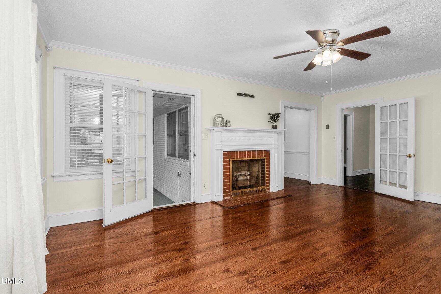 902 Treemont Road Northwest Wilson, NC 27896 - Photo 7 of 43 an empty room with wooden floor a ceiling fan and windows