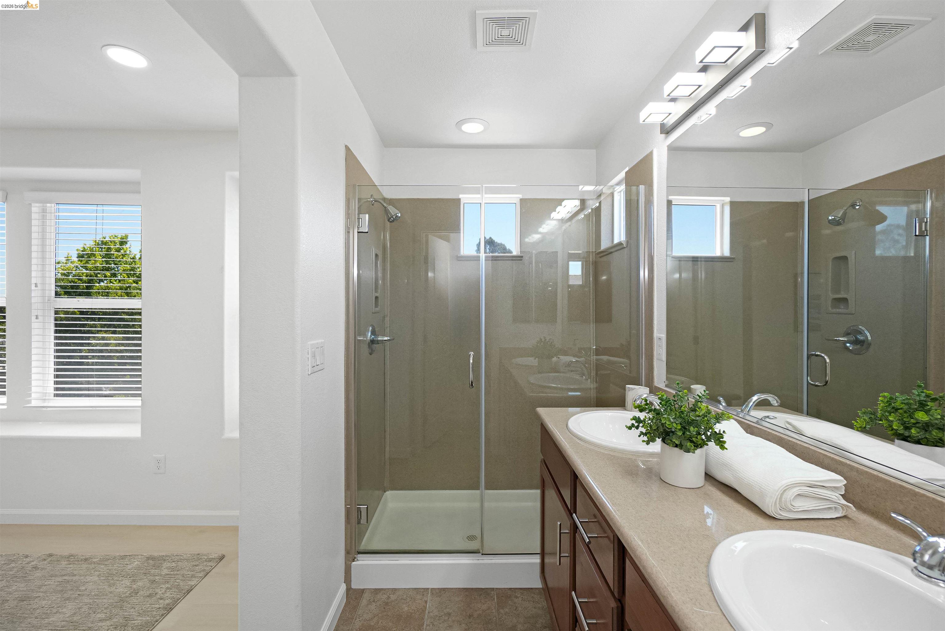 449 Constantine Court San Ramon, CA 94583 - Photo 44 of 63 Double vanity with integrated sinks, a glass-enclosed shower, wood-finish cabinetry, and recessed lighting