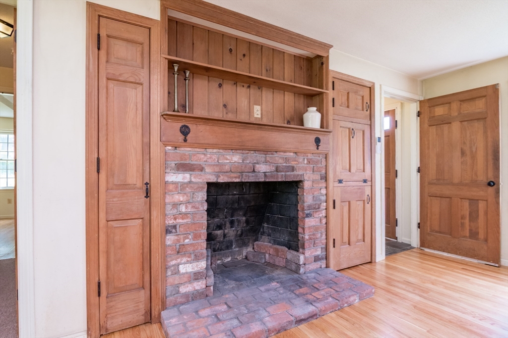 24 South Sunset Avenue Amherst, MA 01002 - Photo 9 of 42 a view of an empty room with wooden floor a fireplace and a window